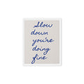 Framed canvas with handwritten navy blue quote "Slow down you're doing fine" on beige background, white pine wood floating frame / Картина с рамка с ръкописен цитат „Забави се, справяш се добре" в тъмносиньо на бежов фон, бяла плаваща рамка